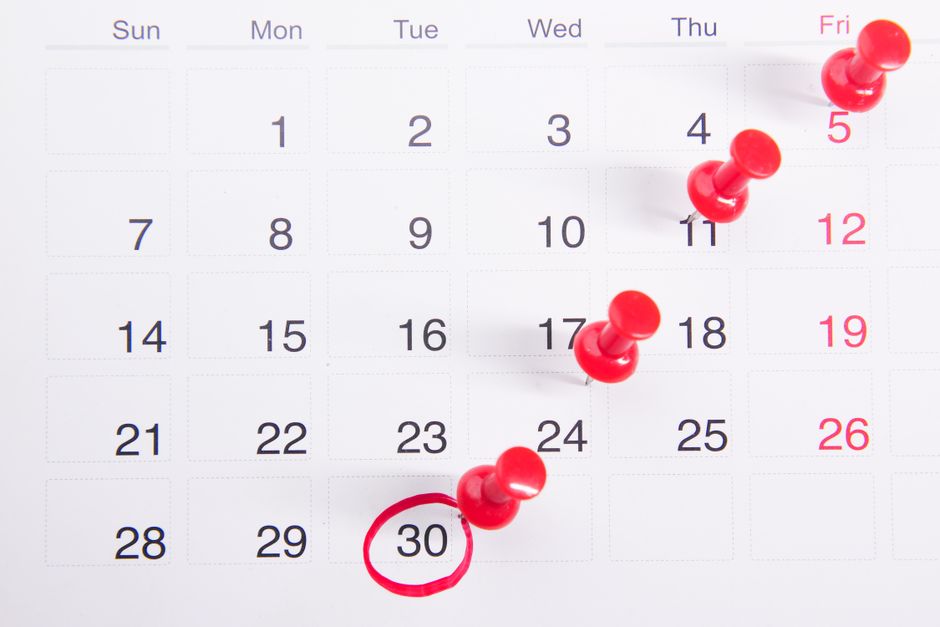 Calendar with push pins marking important health insurance open enrollment dates